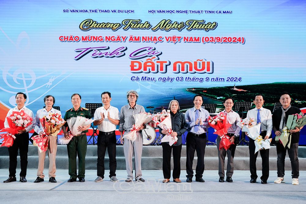 Ông Tiêu Minh Tiên – Phó GĐ Sở VH,TT&DL (thứ 4 bên phải) và ông Lê Minh Nhựt – Phó chủ tịch Hội VHNT tỉnh Cà Mau (thứ 4 bên trái) tặng hoa các tác giả có tác phẩm trong Chương trình nghệ thuật “Tình ca Đất Mũi”. 