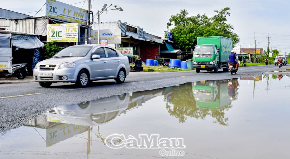 Chỉ có 2 làn đường nhưng gần hết một bên đã ngập nước kéo dài, gây ảnh hưởng giao thông và nguy cơ tai nạn. (Ảnh chụp tuyến Quốc lộ 1 qua địa bàn xã Hưng Mỹ, huyện Cái Nước).