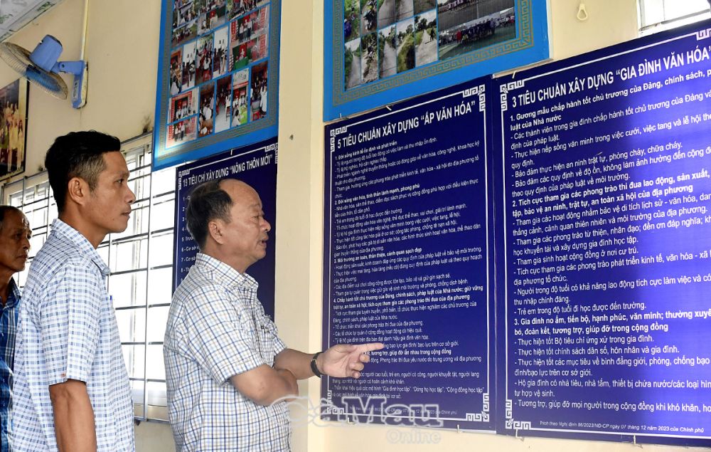 Ông Huỳnh Thanh Hận (đứng trước), Trưởng phòng Văn hoá và Thông tin huyện Thới Bình, kiểm tra việc bày trí hình ảnh, biểu bảng tại Nhà văn hoá Ấp 2.