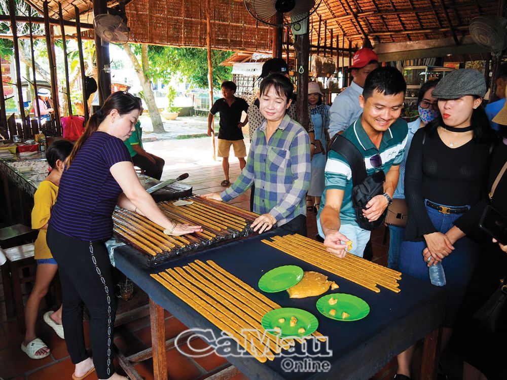 Khách tham quan và có thể thưởng thức món kẹo dừa ngay trong lúc chế biến.