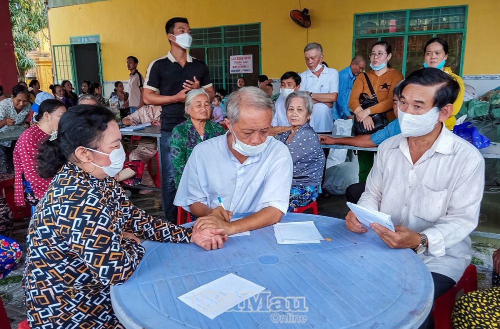 Các công đoạn khám bệnh được thực hiện nhịp nhàng, từ đăng ký, khám và định bệnh, ra toa, bốc thuốc, phát thuốc. (Trong ảnh: Bác sĩ Thái (người ngồi giữa) đang khám và định bệnh).