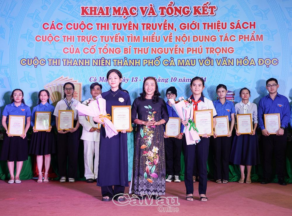 Bà Nguyễn Kim Diệu, Phó giám đốc Thư viện tỉnh, trao giải Nhất cho 2 đơn vị Trường THPT Tắc Vân và Phường 8.