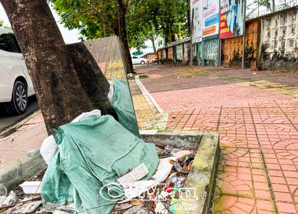 Những mảnh kính cho vào bao vứt ở gốc cây khu vực đường Lê Ðại Hành, Phường 6, TP Cà Mau.