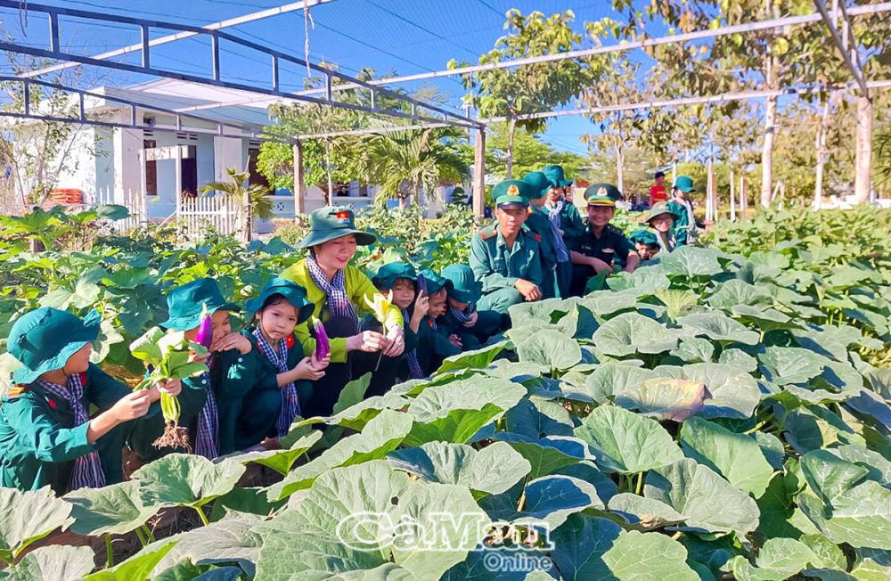 Trẻ hào hứng khi tham quan vườn rau của các chú bộ đội biên phòng.