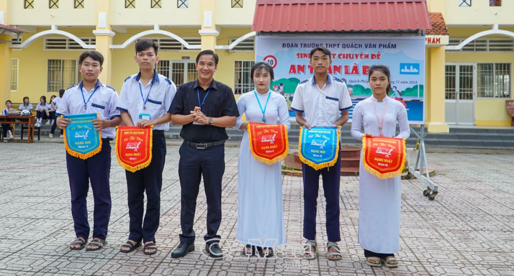 Ðộng viên, khuyến khích và tạo điều kiện để học sinh có môi trường giáo dục toàn diện, giáo dục lý tưởng cách mạng, phẩm chất đạo đức và khát vọng phấn đấu, cống hiến của thế hệ trẻ. (Trong ảnh: Thầy Trần Chí Phong trao cờ thi đua và các phần thưởng cho những tập thể có thành tích xuất sắc, tiêu biểu).