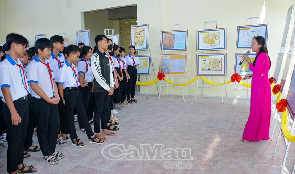 Nhân viên Bảo tàng tỉnh giới thiệu bản đồ, tư liệu, hình ảnh chủ đề “Hoàng Sa, Trường Sa của Việt Nam” đến học sinh huyện Thới Bình trong buổi trưng bày tại xã Trí Phải.