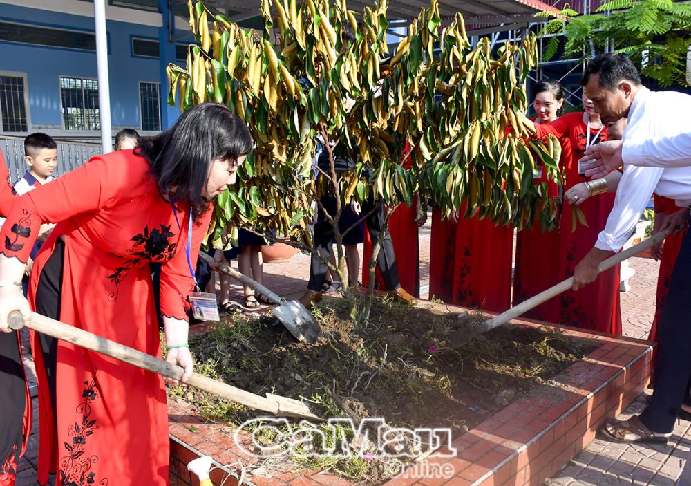 Cô Nguyễn Thu Em (bìa trái) cùng giáo viên, học sinh trồng cây vú sữa trong khuôn viên trường.