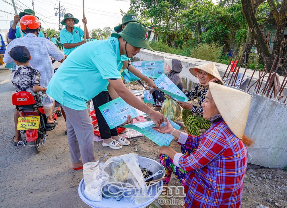 Lực lượng tình nguyện viên phát tờ rơi tuyên truyền ý thức bảo vệ môi trường, không xả rác thải bừa bãi làm mất vẻ mỹ quan đô thị cho bà con buôn bán khu vực Khánh Hội.