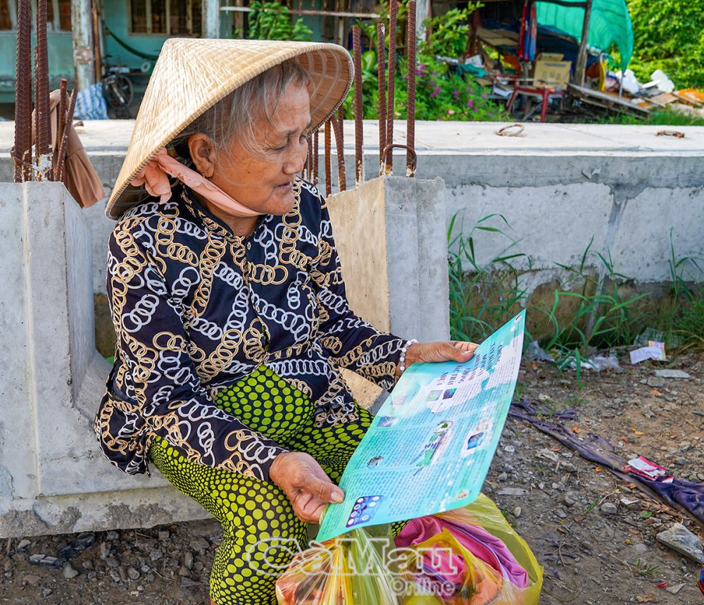 Người dân tìm hiểu nội dung tờ rơi tuyên truyền.