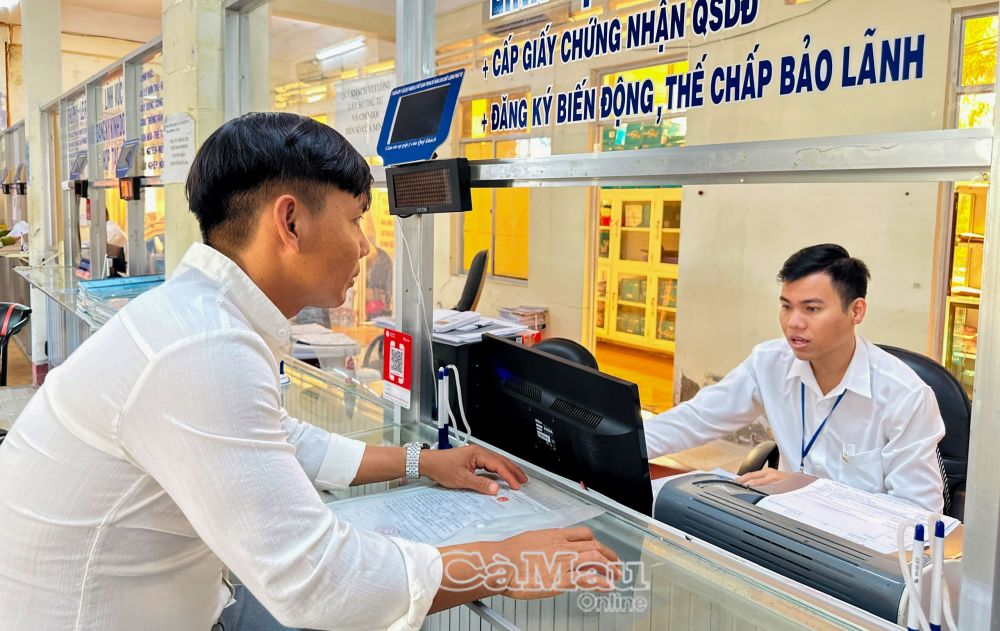 3/ Viên chức chi nhánh Văn phòng đăng ký đất đai huyện Đầm Dơi tiếp nhận hồ sơ TTHC đất đai của người dân tại bộ phận một cửa huyện.