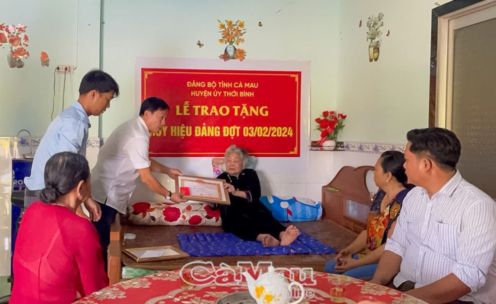 Ông Huỳnh Quốc Hoàng, Bí thư Huyện uỷ Thới Bình, trân trọng trao Huy hiệu 55 tuổi Ðảng cho bà Nguyễn Thị Quý. (Ảnh gia đình nhân vật cung cấp)