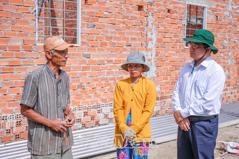 Ông Lê Thanh Triều (bìa phải) kiểm tra tiến độ xây mới, sửa chữa nhà ở thuộc chương trình xoá nhà tạm, nhà dột nát tại xã Trí Lực, huyện Thới Bình.