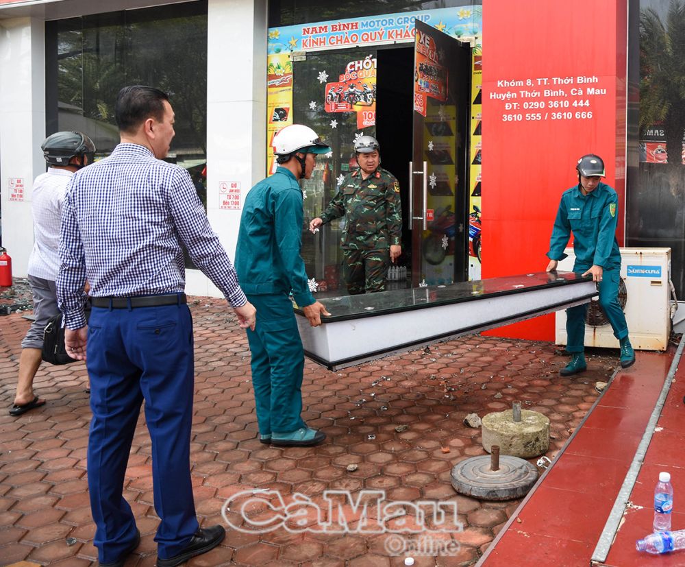 Lực lượng dân quân tự vệ tại địa phương hỗ trợ cơ sở bị cháy dọn dẹp, khắc phục hậu quả.