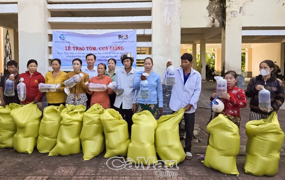 Người dân phấn khởi khi nhận tôm, cua giống và vật tư thực hiện mô hình phát triển kinh tế.