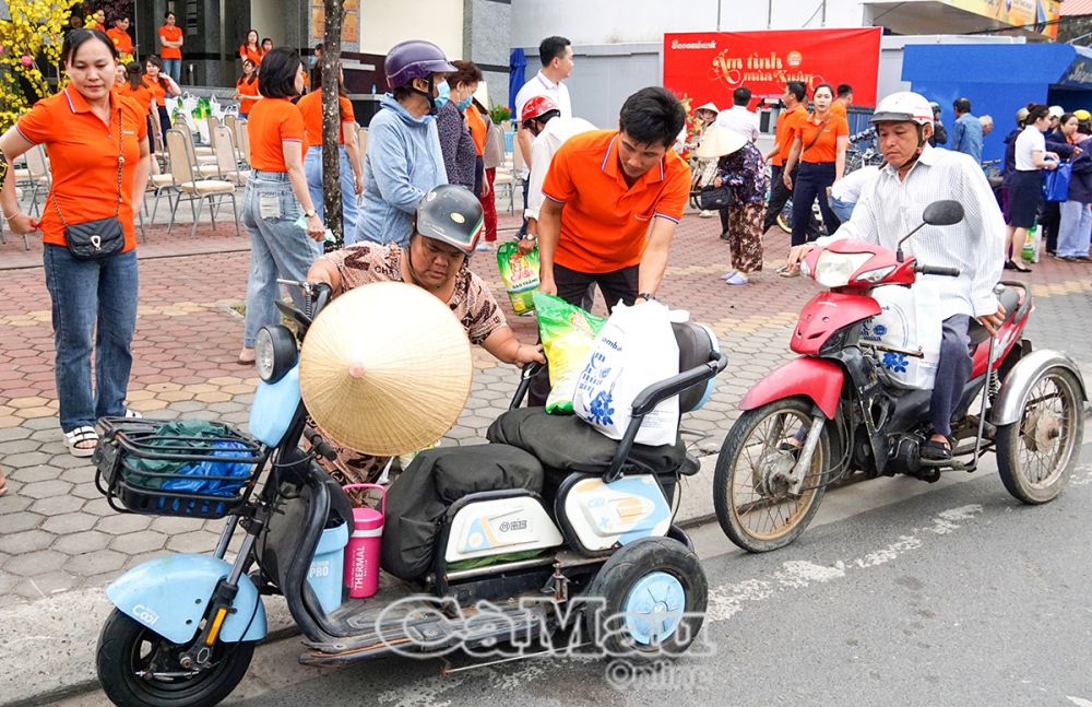 Nhân viên Sacombank Chi nhánh Cà Mau hỗ trợ người dân mang quà về nhà.