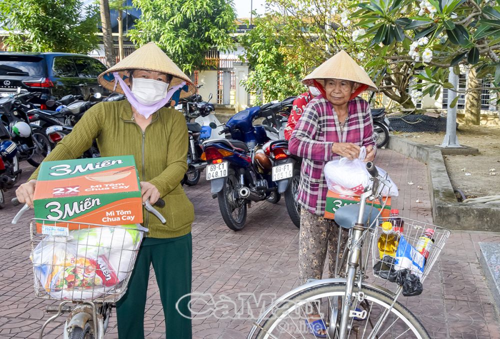 Người dân phấn khởi mang quà về cho gia đình.