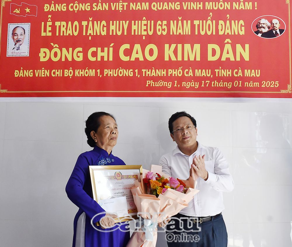 Phó Bí thư Thường trực Tỉnh ủy Nguyễn Đức Hiển đến trao tặng Huy hiệu 65 năm tuổi Đảng và tặng hoa chúc mừng đồng chí Cao Kim Dân.