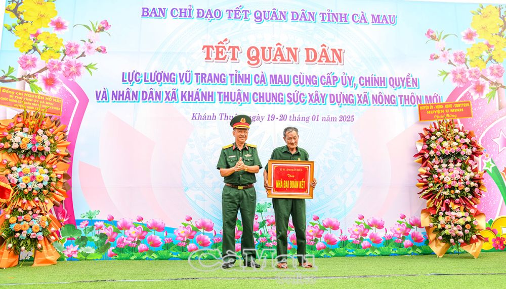 Đại tá Nguyễn Thanh Phong, Chính uỷ Bộ Chỉ huy Quân sự tỉnh, trao trượng trưng Nhà đại đoàn kết cho hộ nghèo.