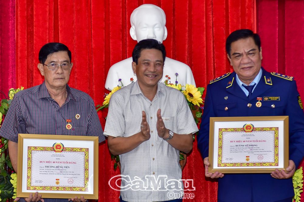 01/- Đồng chí Lê Bình Nguyên, Phó bí thư thường trực Đảng uỷ Dân Chính Đảng, trao Huy hiệu 40 năm tuổi Đảng cho 2 đảng viên đang sinh hoạt tại đảng bộ trực thuộc.