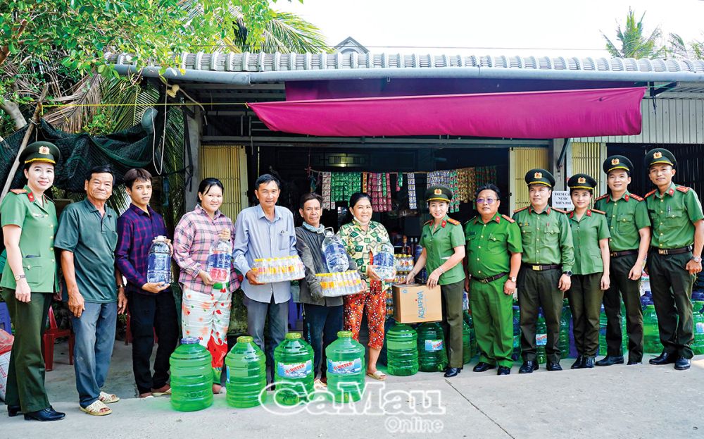 Cán bộ, chiến sĩ Công an tỉnh Cà Mau hỗ trợ nước uống cho người dân ấp Thanh Tùng, xã Biển Bạch, huyện Thới Bình bị ảnh hưởng bởi khô hạn.