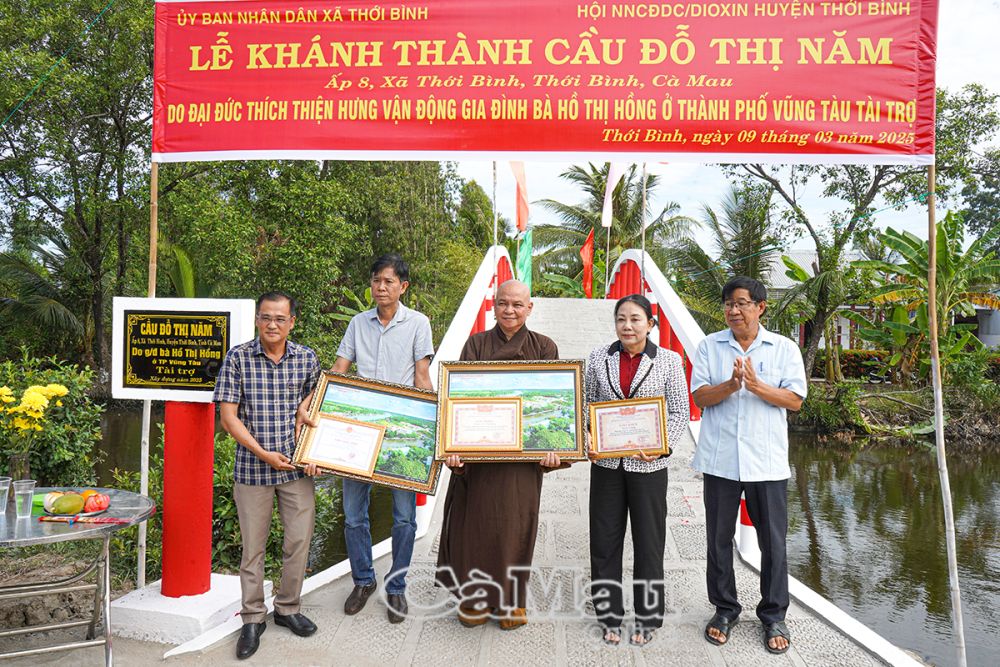  Ông Đỗ Hữu Lực, Chủ tịch Hội NNCĐDC/Dioxin huyện Thới Bình (bìa phải) và ông Đặng Hoàng Hùng, Phó chủ tịch UBND xã Thới Bình trao bảng tấm lòng vàng và quà của huyện cho nhà tài trợ.