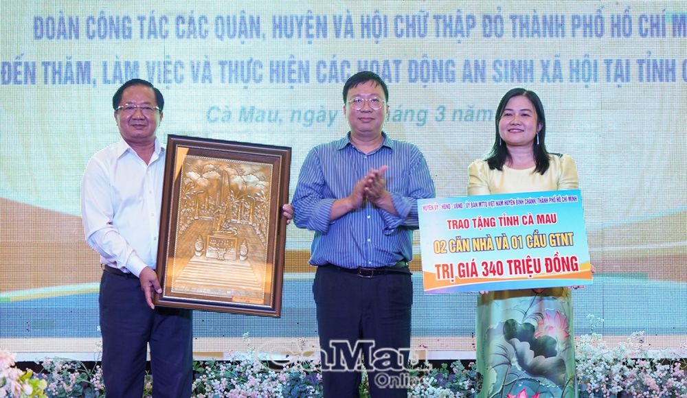 9/ Ông Nguyễn Thanh Nhã, Bí thư Huyện uỷ Bình Chánh, trao bảng tượng trưng 2 căn nhà và 1 cây cầu nông thôn, tổng trị giá 340 triệu đồng, cho lãnh đạo MTTQ tỉnh Cà Mau.