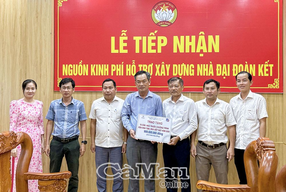 Thừa uỷ quyền của Tổng Công ty Ðiện lực miền Nam, ông Thiều Văn Minh, Phó giám đốc Công ty Ðiện lực Cà Mau (thứ ba từ phải sang), trao khoản hỗ trợ xây dựng 15 căn nhà trong Chương trình xoá nhà tạm, nhà dột nát của tỉnh.