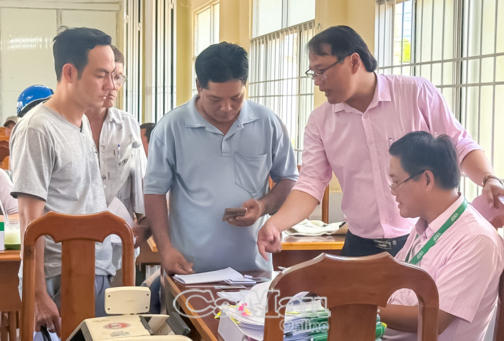 Anh Phạm Văn Cường (bìa trái) hỗ trợ người dân đến giao dịch tại xã Hàng Vịnh.