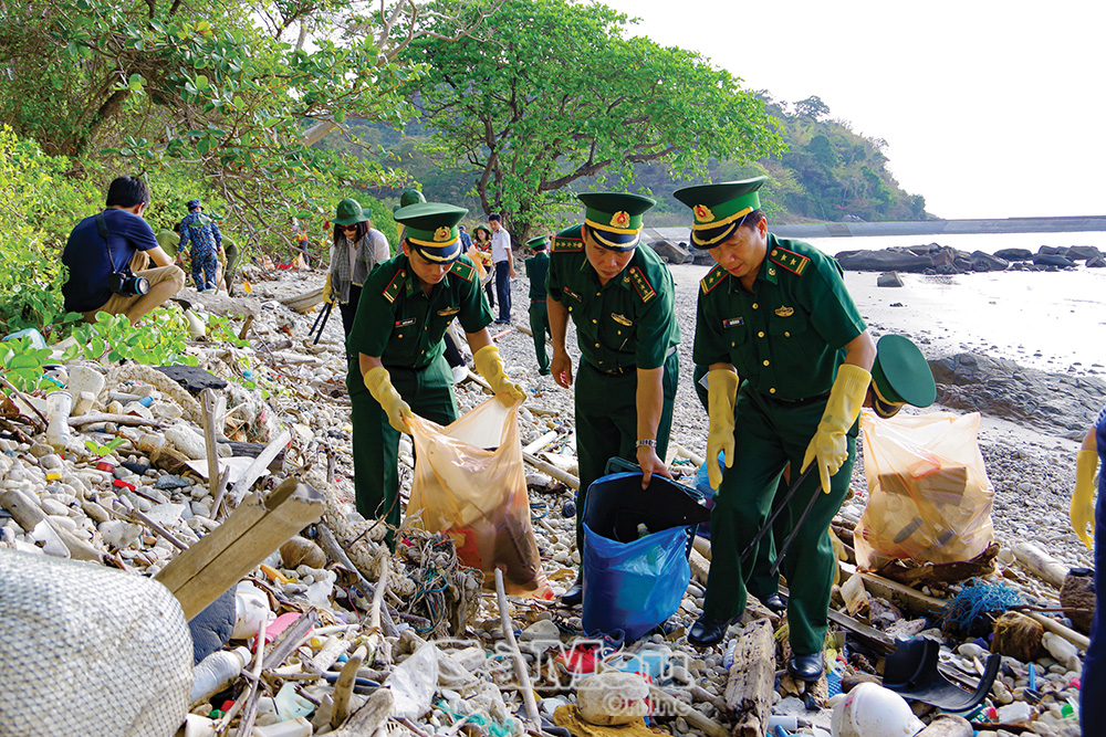 Cán bộ, chiến sĩ Ðồn Biên phòng cùng các lực lượng chức năng trên đảo Hòn Khoai ra quân dọn rác thải. Ảnh: LÊ KHOA