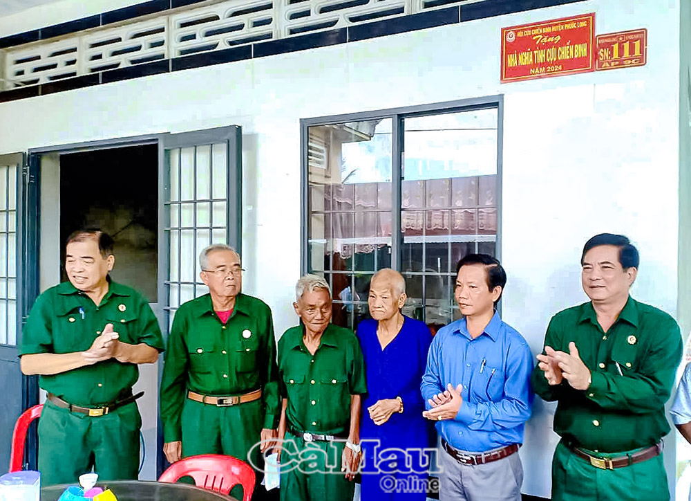Cựu chiến binh Ngô Văn Bá (thứ 2 từ trái sang) trao nhà “Nghĩa tình Cựu chiến binh” cho ông Dương Minh Cầu.