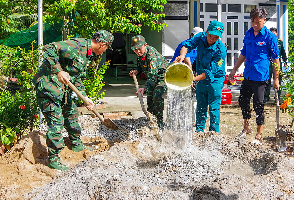 Người lính Cụ Hồ giúp dân làm nhà, làm đường giao thông, khắc phục hậu quả thiên tai. Ảnh: Văn Đông
