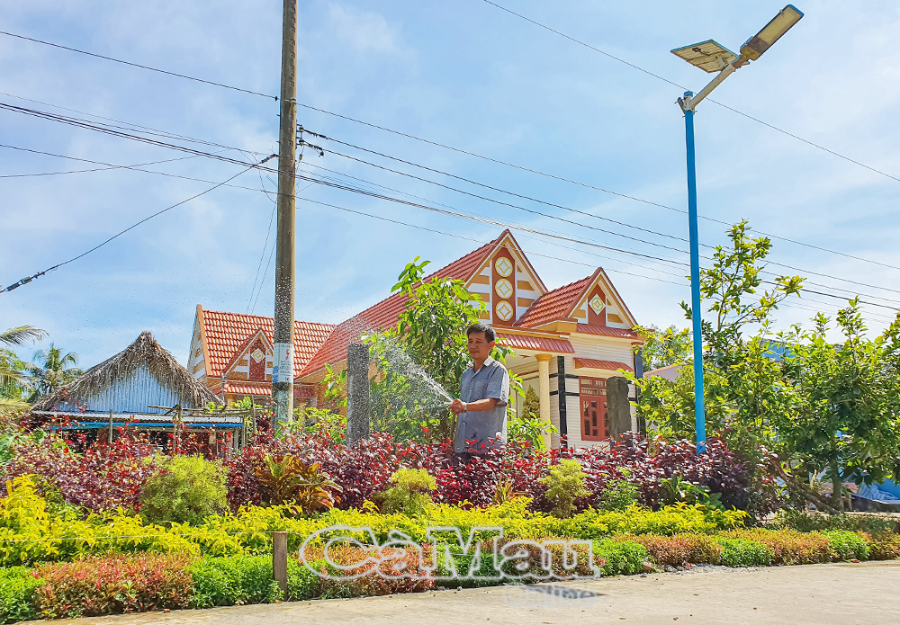 Người dân chăm sóc hàng rào cây xanh trước nhà, tạo cảnh quan môi trường xanh - sạch - đẹp.