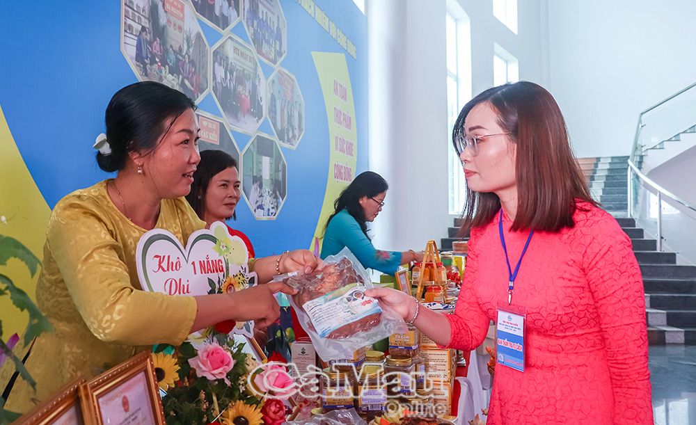 Chị Huỳnh Như (bìa trái) giới thiệu sản phẩm cá rô phi một nắng tại khu vực trưng bày các đặc sản, bên lề Ðại hội Ðại biểu Phụ nữ tỉnh Cà Mau, nhiệm kỳ 2025-2030.