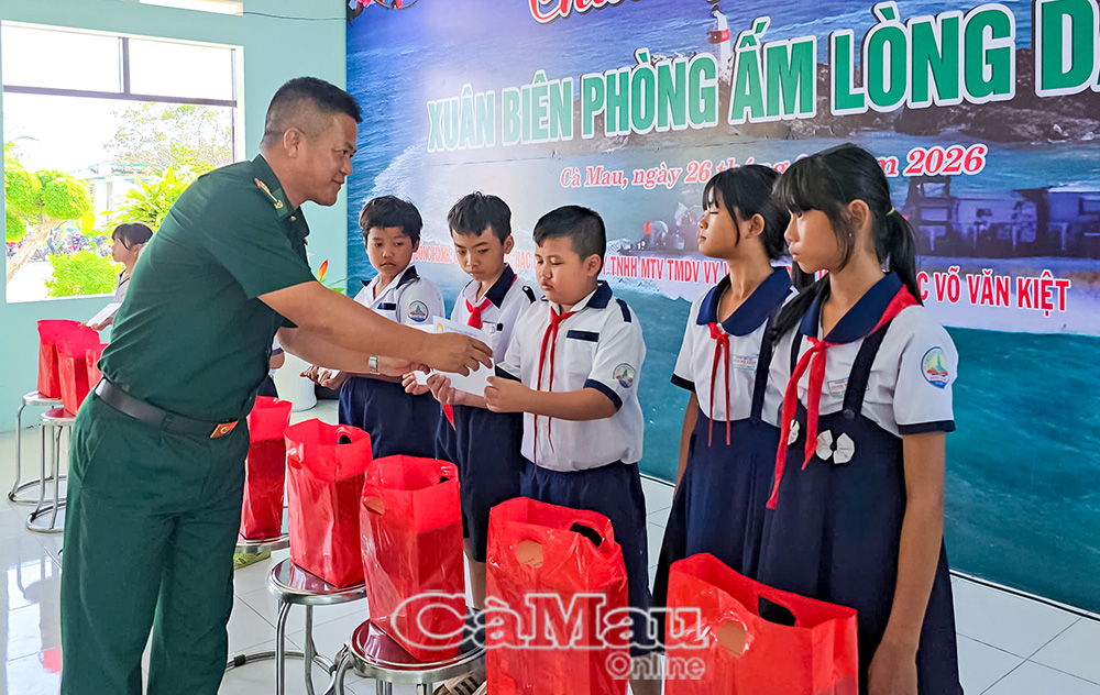 Trung tá Hoàng Văn Dũng, Ðồn trưởng ÐBP Nhà Mát, trao quà và học bổng cho học sinh nghèo hiếu học của địa phương nơi đóng quân.