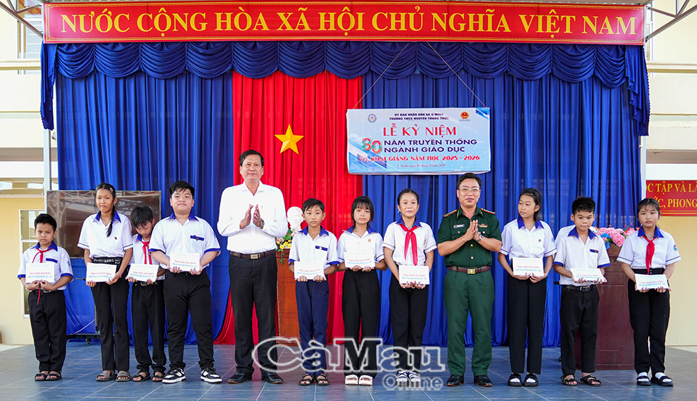 Ðại tá Phạm Minh Giang, Bí thư Ðảng uỷ - Chính uỷ BÐBP tỉnh và lãnh đạo UBND xã U Minh trao học bổng cho học sinh Trường THCS Nguyễn Trung Trực.