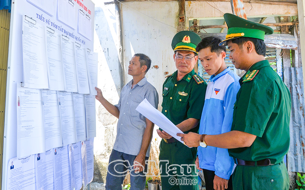 Cán bộ Ðồn Biên phòng Khánh Tiến hướng dẫn người dân xem danh sách ứng cử viên được niêm yết tại các điểm bầu cử trên địa bàn xã U Minh.