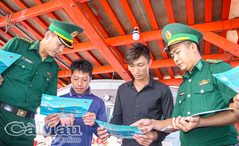 Cán bộ Ðồn Biên phòng Gành Hào phát tờ rơi, tuyên truyền pháp luật cho ngư dân.