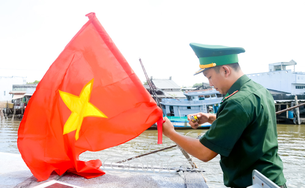 Cán bộ Đồn Biên phòng Cái Đôi Vàm thay cờ Tổ quốc cho tàu cá của ngư dân vươn khơi bám biển