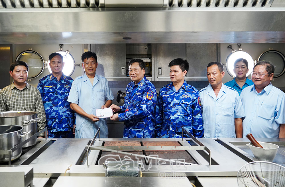 Thiếu tướng Trần Văn Xuân, Phó Chính uỷ Cảnh sát biển Việt Nam (thứ tư từ trái sang) trao quà hỗ trợ cho đại diện cán bộ, chiến sĩ làm công tác hậu cần, phục vụ trên Tàu CSB 8005.