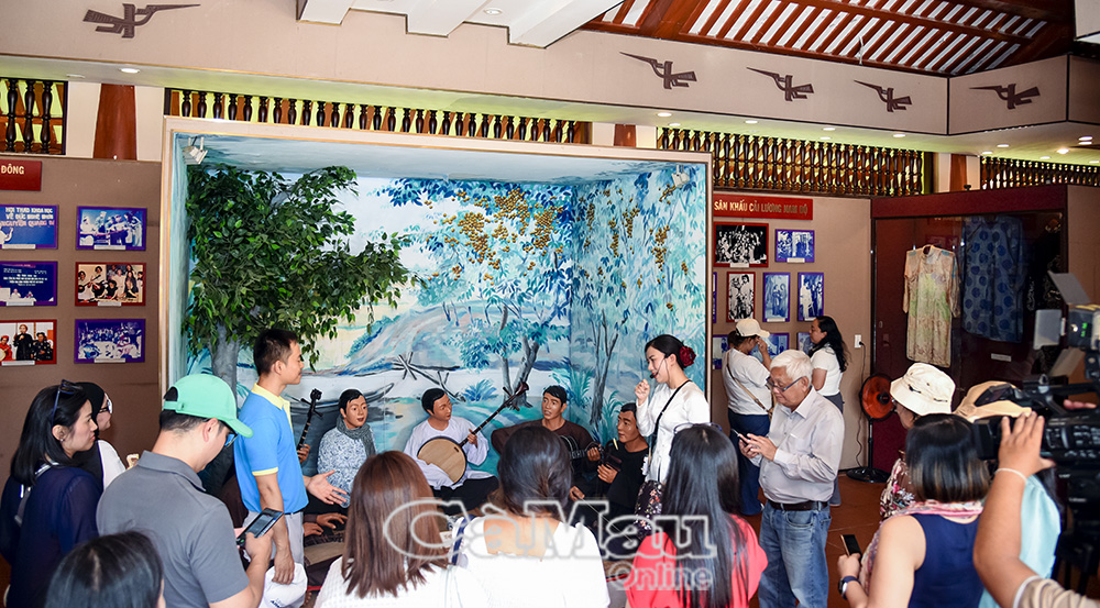 Du khách nghe thuyết minh về Khu Lưu niệm Nghệ thuật đờn ca tài tử Nam Bộ và Nhạc sĩ Cao Văn Lầu.
