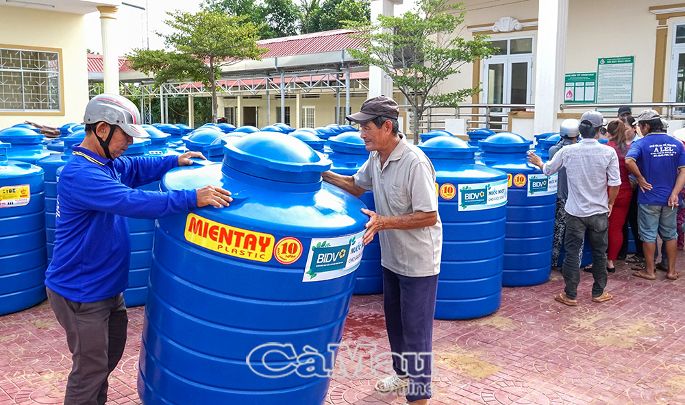 Người dân xã Trí Phải nhận bồn nước do BIDV Cà Mau hỗ trợ.